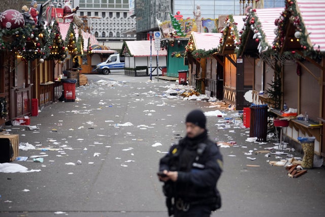 En polis vid den avspärrade julmarknaden i Magdeburg, där flera personer omkom när en bil körde in i en folkmassa på lördagen.