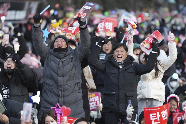 Skål i folkmassorna i Seoul när beslutet om riksrätt har fattats.