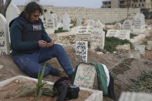 En journalist ber vid fotojournalisten Anas Alkharboutlis grav i Idlib. Alkharboutli dödades i ett flyganfall nära Hama denna vecka.