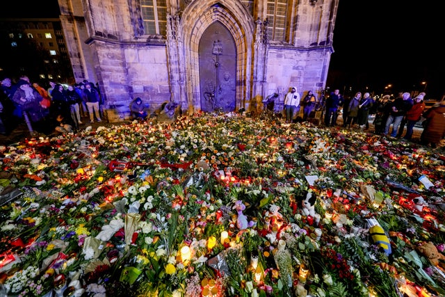 Blommor och ljus utanför en kyrka nära julmarknaden.