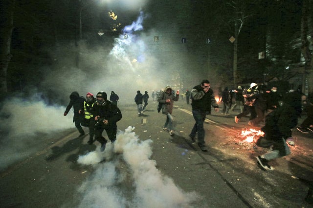 Demonstranter flyr från polisen efter att tårgas satts in under natten mot söndagen.