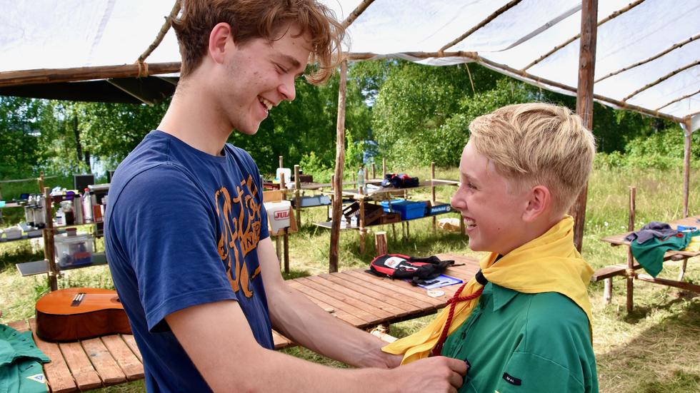 12-årige Theodor Wickstrand får hjälp att rätta till scarfen av ledaren Tim Berndtsson, 17. 