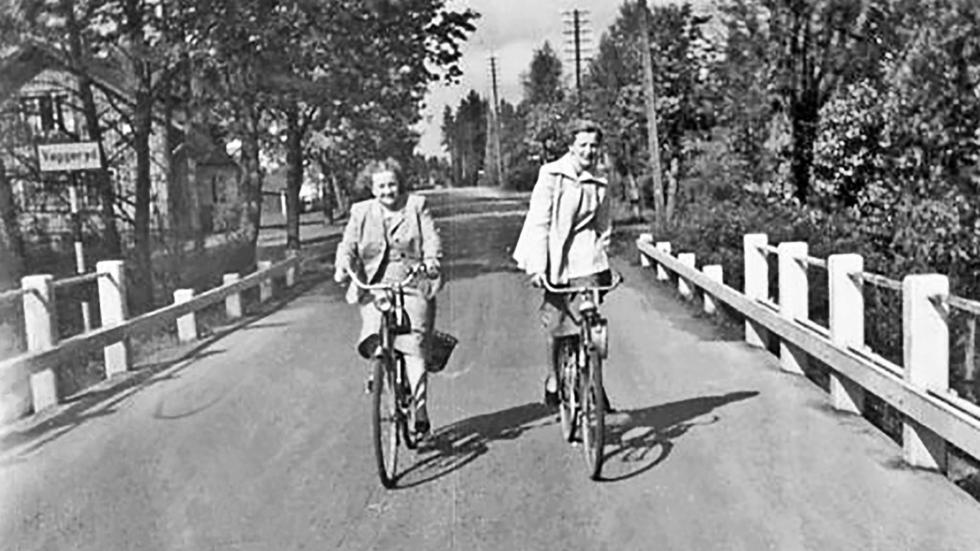 Ingegerd Norum, född Lundkvist,  och Zara Tengblad, född Andersson har, enligt bokens bildtext, bråttom hem till Götafors. Här cyklar de alltså längs E4, eller ”Riksettan”, som vägen hette då.