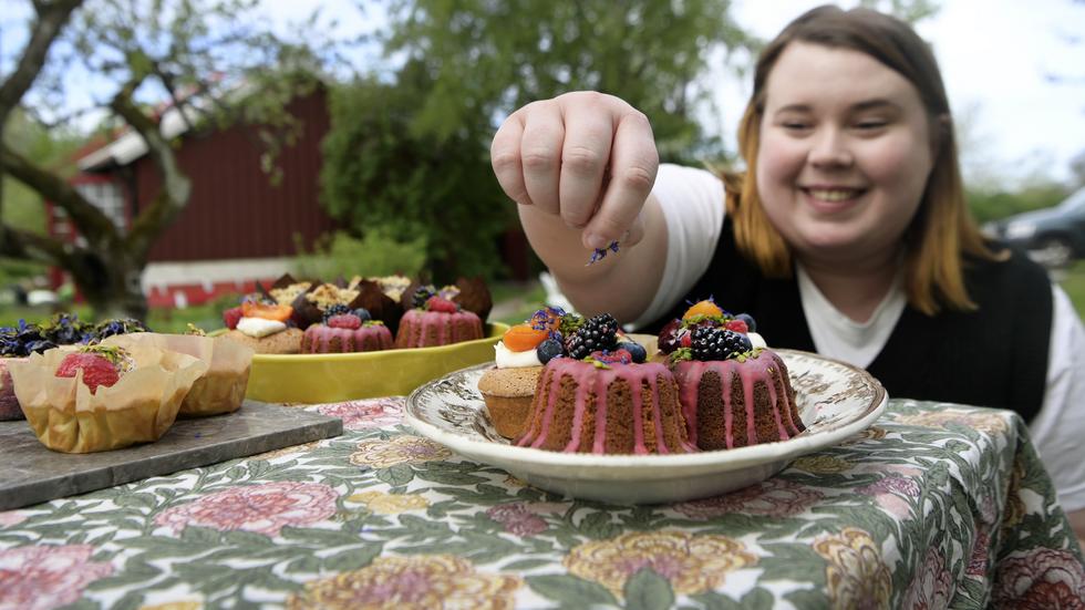 Martina Thörnmo strör blåklint över ett av  bakverken. Närmare bestämt en teacake gjord på lavendelhonung som är toppad med björnbärsglasyr och vilda bär. 