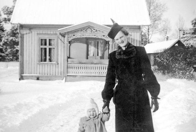 Kerstin Bergman är påpälsad för en vinterpromenad med dottern Kerstin. Huset, som stod på Norra Bruksgatan 8, är rivet i dag.