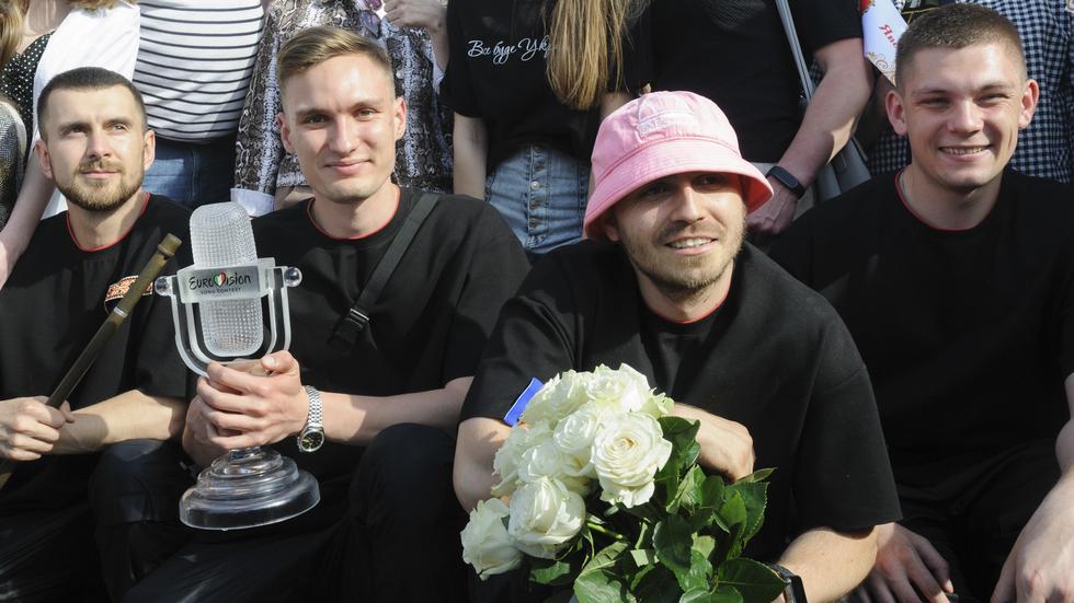 Oleh Psiuk i sin rosa mössa och resten av medlemmarna i Kalush Orchestra poserar med fans. Bandet auktionerat ut statyetten och mössan. 
Arkivbild: Mykola Tys/AP