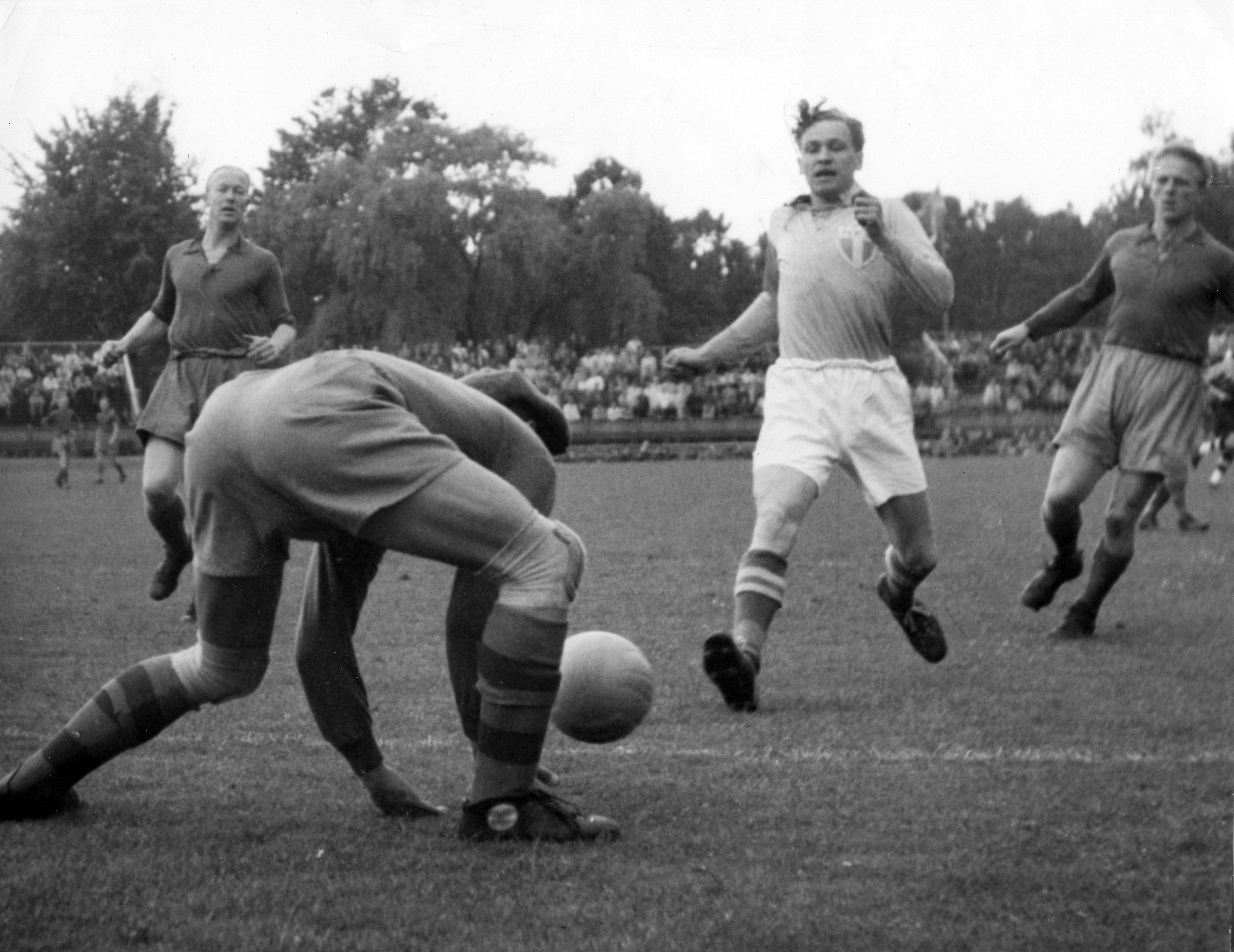 HIF-keepern Kalle Svensson plockar upp bollen framför fötterna på Henry Thillberg i en allsvensk match 1952.
