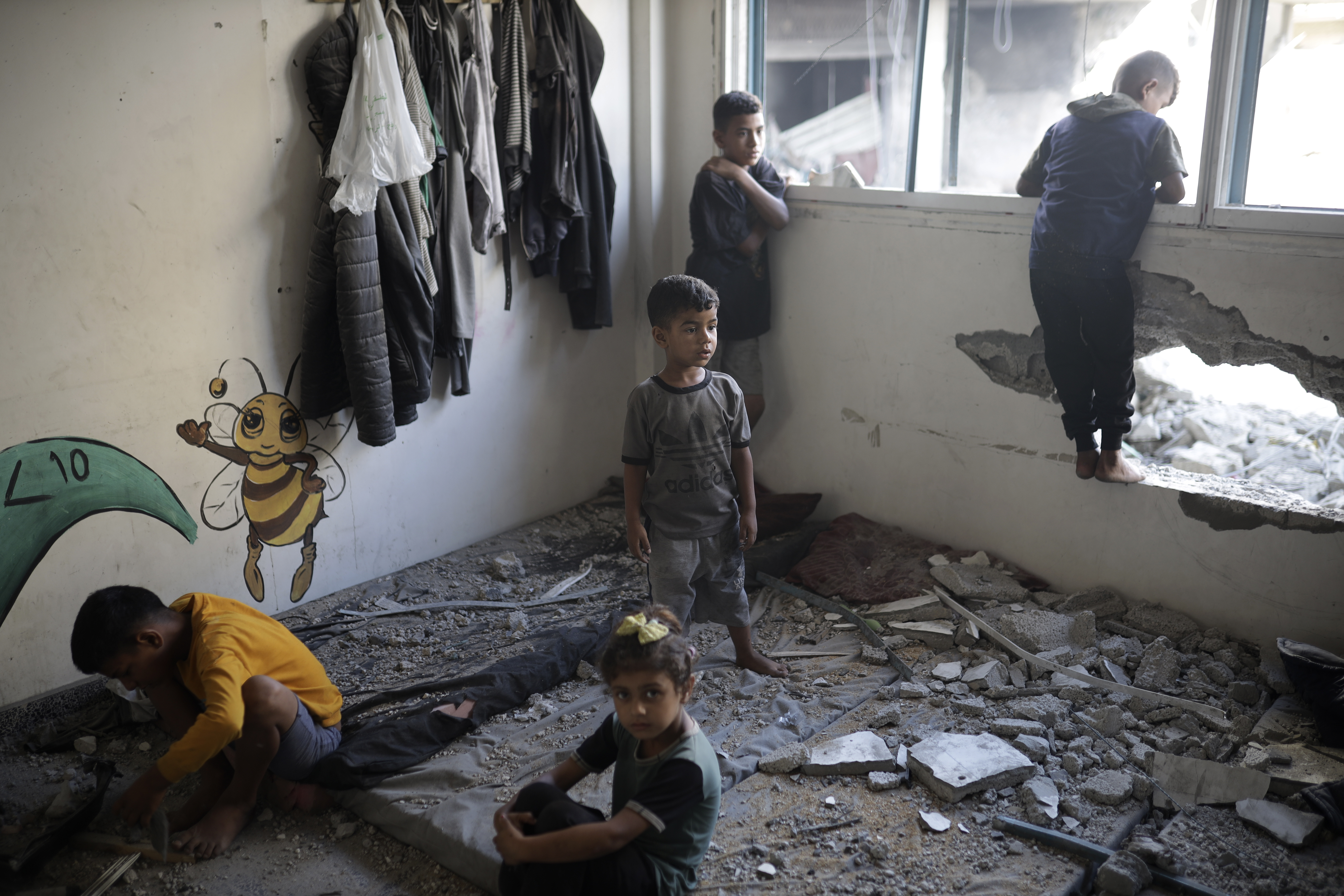 Bambini palestinesi tra le rovine di una scuola dell'UNRWA a Khan Yunis utilizzata come alloggio per i rifugiati.  Foto scattata il 21 giugno.