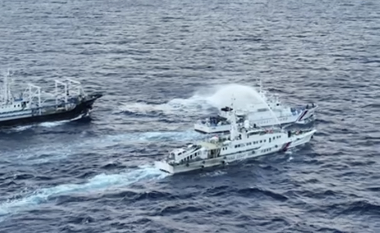 På bilden syns ett fartyg från den kinesiska kustbevakningen använda vattenkanon mot en filippinsk båt nära den omstridda atollen Second Thomas Shoal vid Spratlyöarna. Fotot är taget den 10 december.