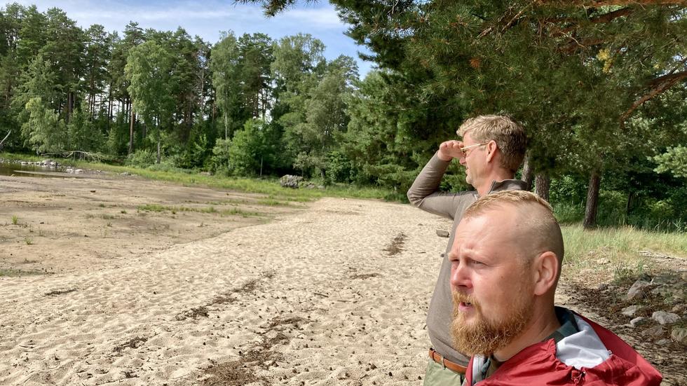 Jakob Olofsgård (L) och Thomas Ivung, Svenska Rovdjursföreningen, spanar söderut över Nässjön. På västra sidan av sjön inne i skogen finns färska spår av varg.