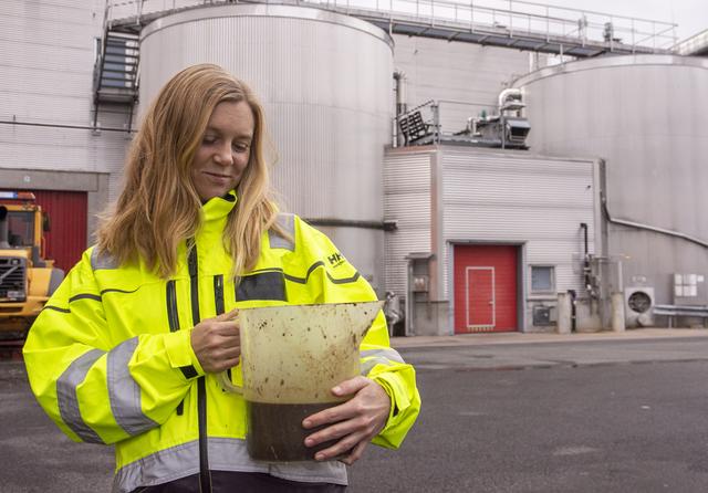 Caroline Svensson, miljö- och avfallsstrateg vid June Avfall & Miljö, tog oss med till avfallsanläggningen på Torsvik. Här håller hon i en behållare med så kallad 