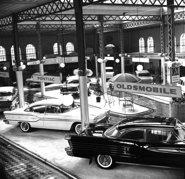 1958. Utställning av nya och begagnad bilar i saluhallen på Lilla torg. Frågan är: hur fick man in bilarna?