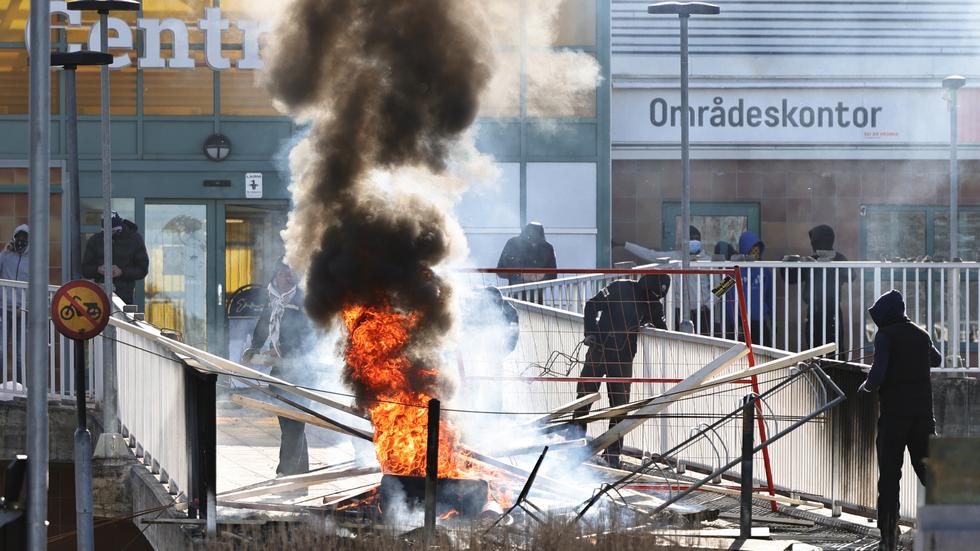 Personer gör en barrikad med brinnande bildäck och andra föremål vid Ringdansen centrum, i samband med upplopp i Navestad i Norrköping på påskdagen.

Foto: Stefan Jerrevång / TT 