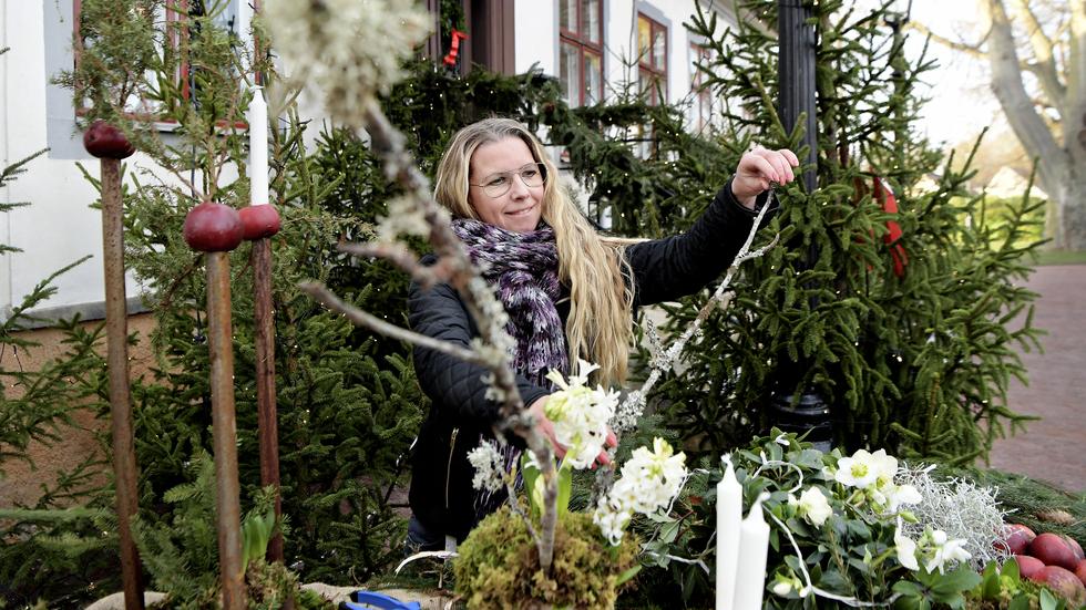Anna Lax, enhetschef på verksamhetsservice, hänger upp ljusslingor utanför Rosenlunds herrgård för att skapa rätt julstämning.