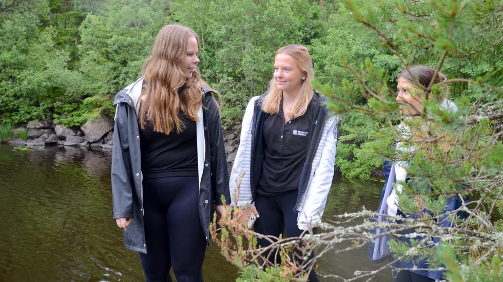 Elin Randåker tar med sina 17-åriga feriepraktikanter Amma Sandin och Aikalin Salmo upp på en klippa ovanför Lyngemadssjön. De kan sedan berätta för andra om upplevelsen.