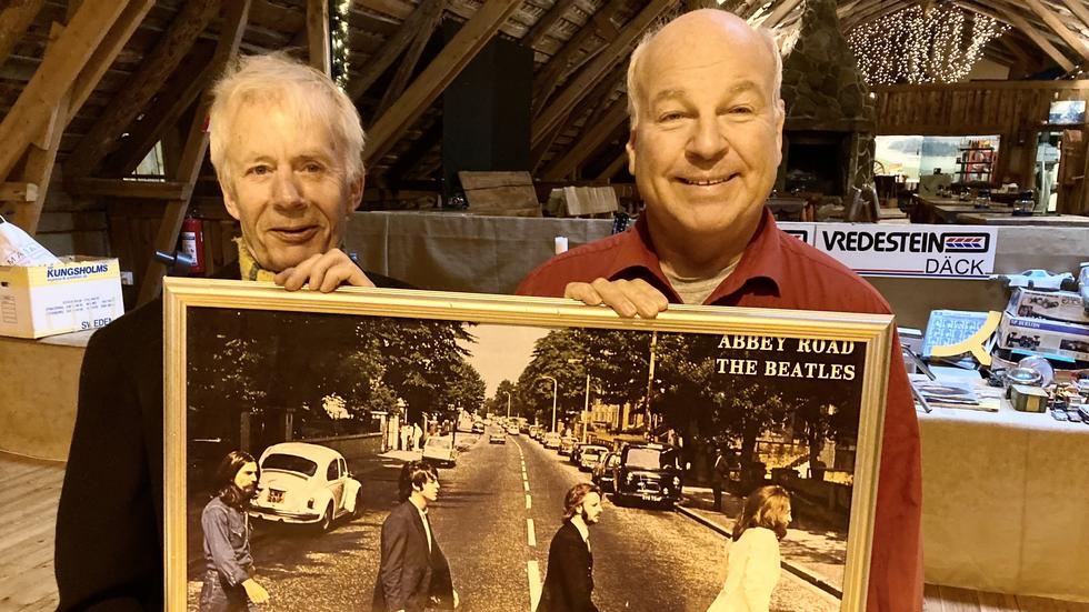 Olle Schenberg och Lars Kyrkeryd visar upp en inramad affisch med omslagsbilden till Beatles lp Abbey Road. 