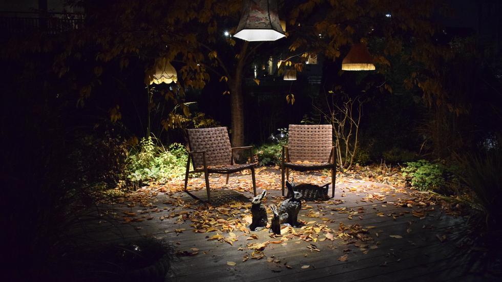 Möbler, växter, ljus och skulpturer bidrar alla till en helhet i Åsa Karlssons trädgård. 