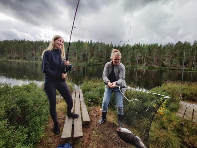 Redaktionens Jenny Karlsson och Nikki Chadly landar med gemensamma krafter en rejäl fisk.