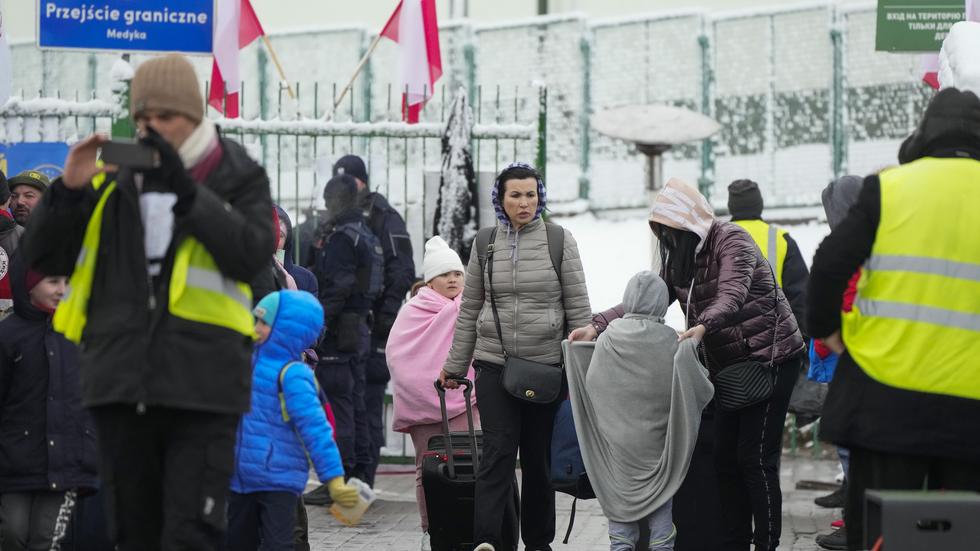 Ukrainska flyktingar passerar gränsen vid polska Medyka. FOTO: AP. 