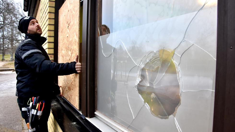 Vaktmästare på Gunnarsboskolan sätter upp träskivor efter att skolan fått åtta fönsterrutor krossade i december 2021.