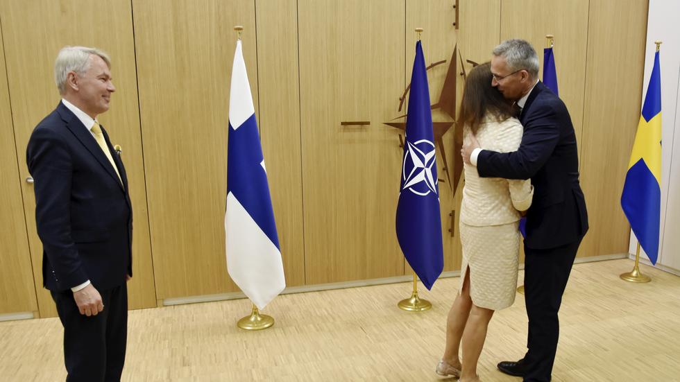 Finlands utrikesminister Pekka Haavisto ser på när Natochefen Jens Stoltenberg välkomnar Sveriges utrikesminister Ann Linde med en kram i Bryssel. Bild. Wiktor Nummelin  / TT