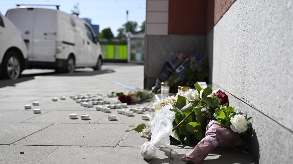 Blommor vid platsen i Älvsjö där en pojke knivmördades början av juni förra året. Arkivbild.
