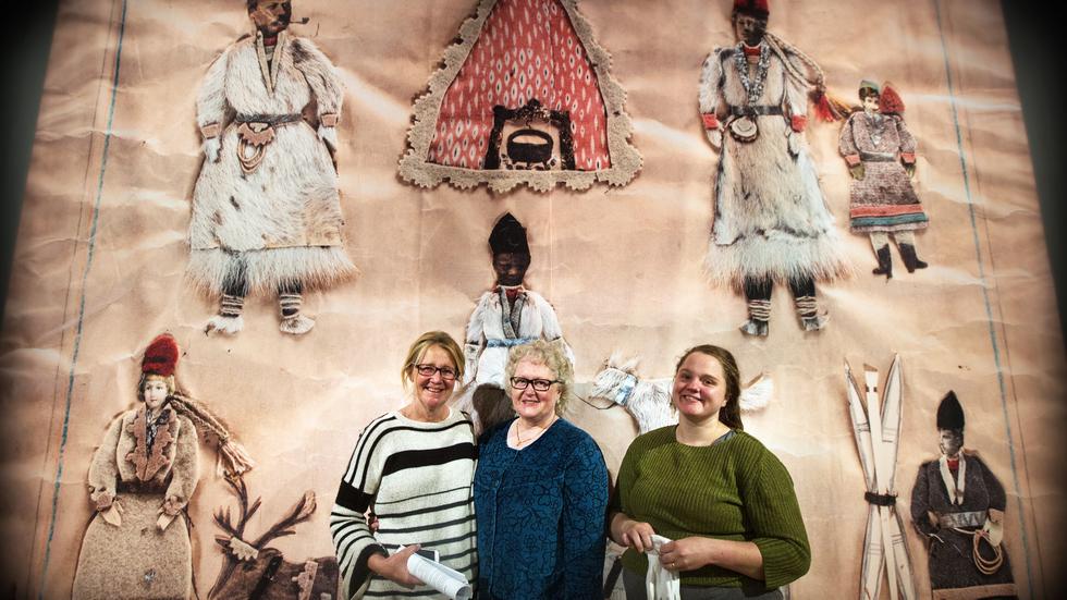 Mona Nilsson, Marie Pettersson och Sandra Gybo framför en förstoring av ett av Sigrid Mårtensdotters collage.