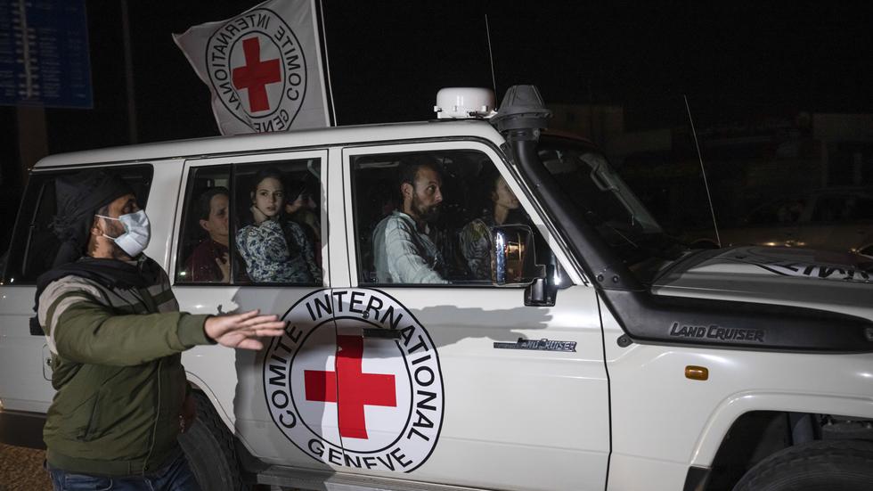 Ett av Röda Korsets fordon kör gisslan i Gazaremsan till gränsövergången Rafah mot Egypten på söndagen.