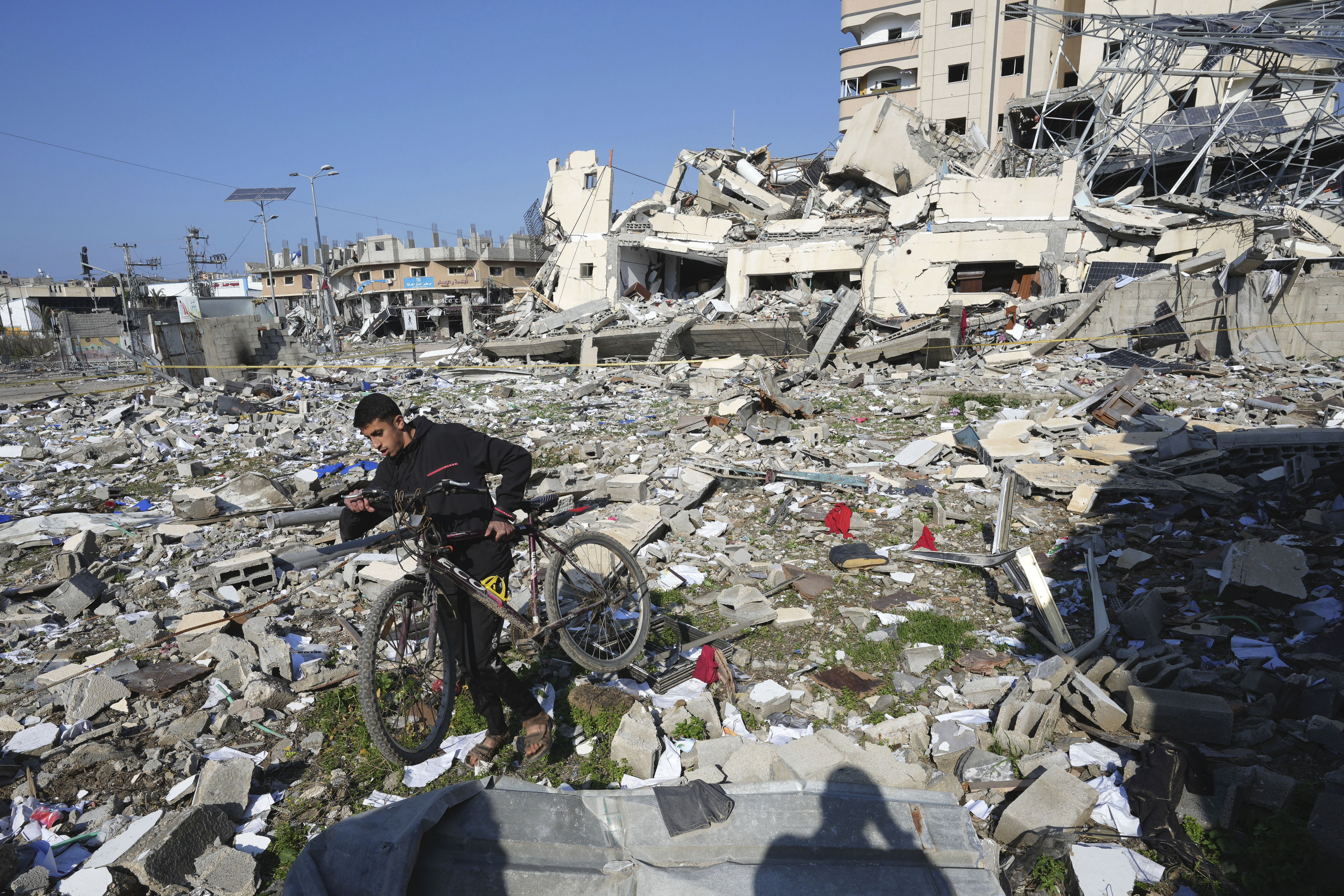 En man försöker ta sig igenom ett förstört kvarter i Gaza på tisdagen.
