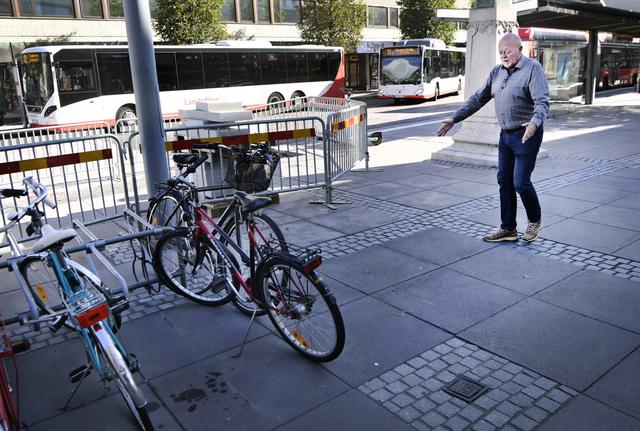 Carlos Trischler visar en tänkbar plats, intill ett cykelställ, för parkering av elsparkcyklar.