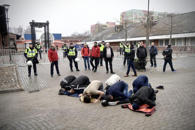 Några personer i bön vid Råslätts centrum. Strax därefter valde den högerextrema politikern Rasmuns Paludan att bränna koranen inför åskådarna. 