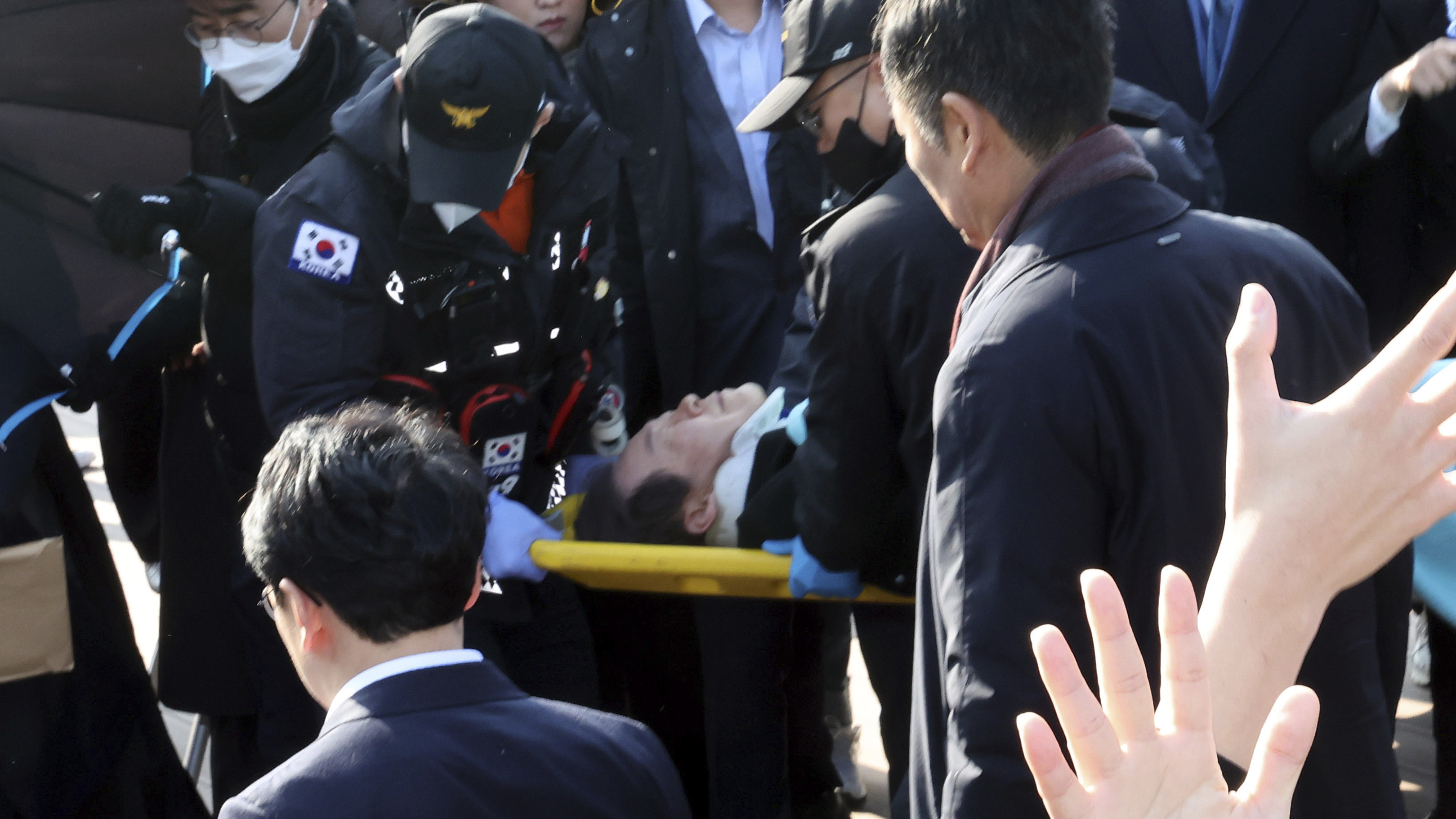 Sydkoreas oppositionsledare Lee Jae-Myung bärs bort på bår efter knivattacken i Busan.