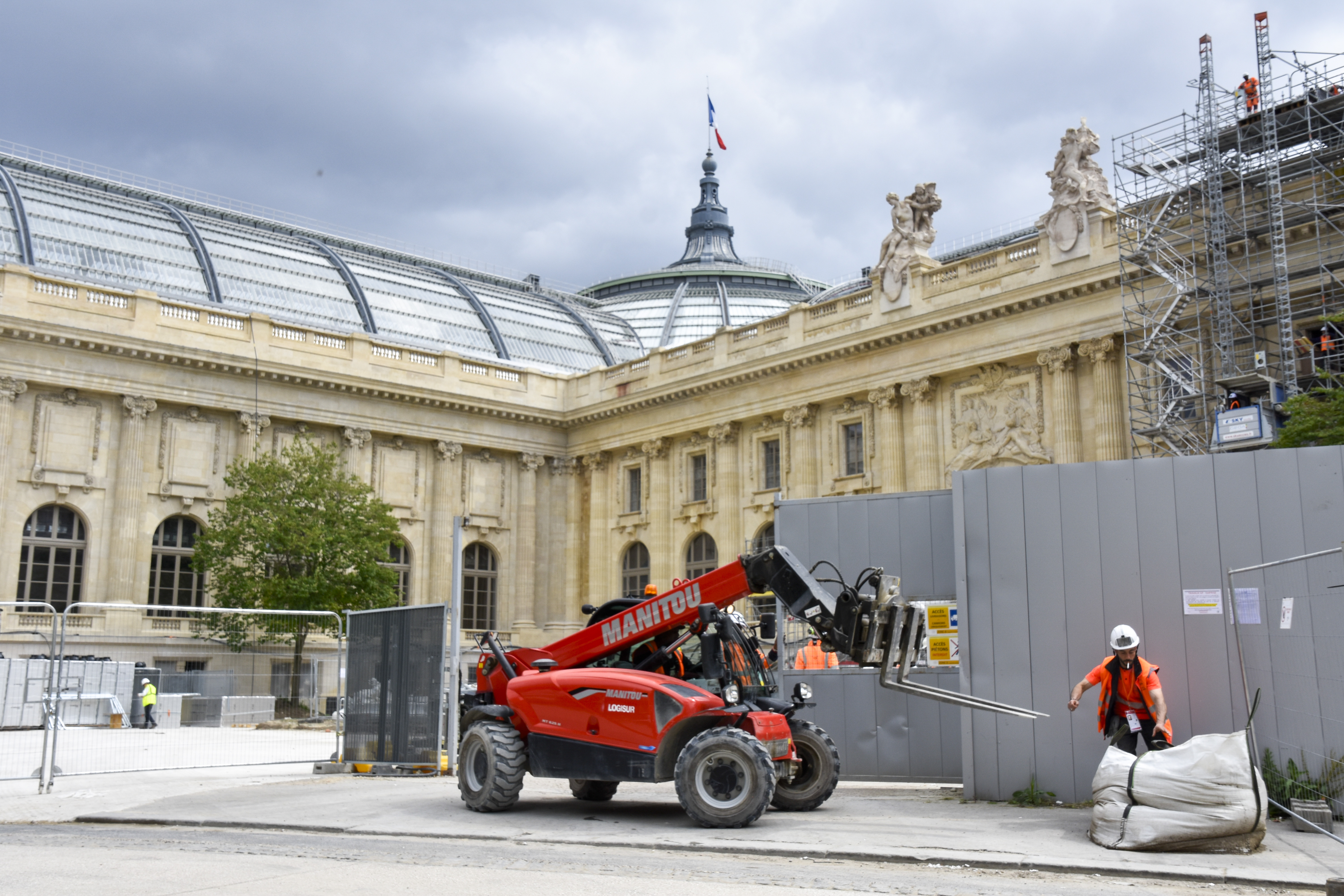 Byggarbetare i full fart vid Grand Palais i Paris där OS-tävlingarna i fäktning och taekwondo ska avgöras.