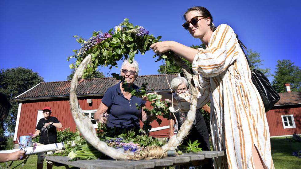 Lilian Svensson och Evelina Sundqvist klär midsommarstången. ”Det är viktigt att folk engagerar sig för att hålla traditionen vid liv”, säger Evelina Sundqvist.