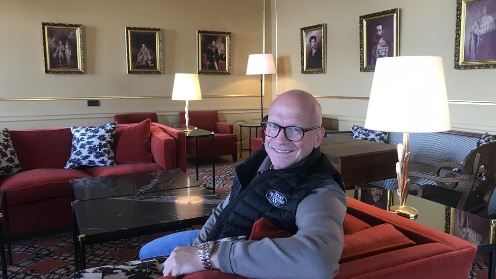 Hans Edberg sittande i Bernadotte-salongen, där tavlor på alla kungar i ätten Bernadotte hänger på väggarna.