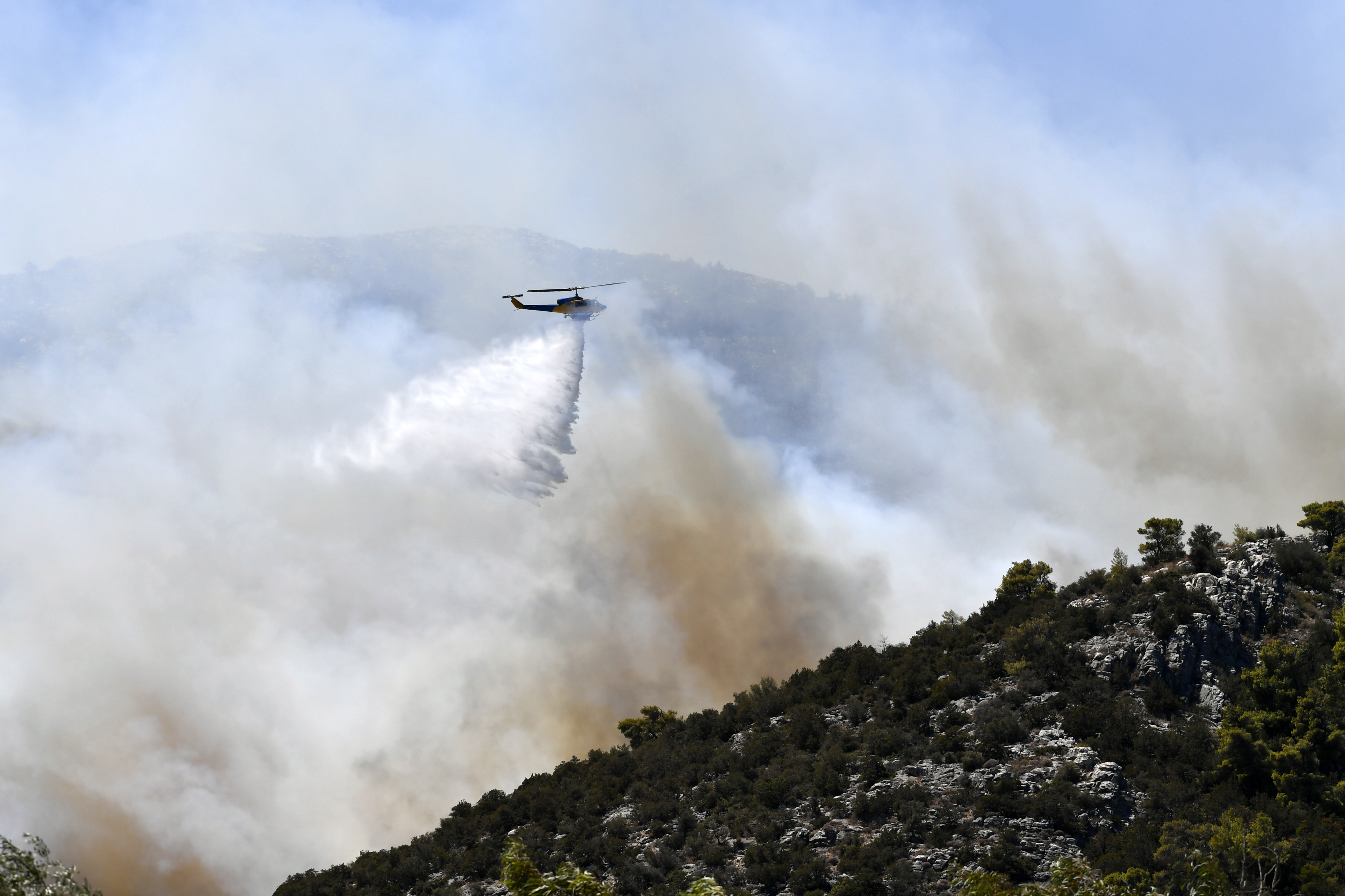 Helicopter bombs Nea Makri, east of Athens, with water bombs.