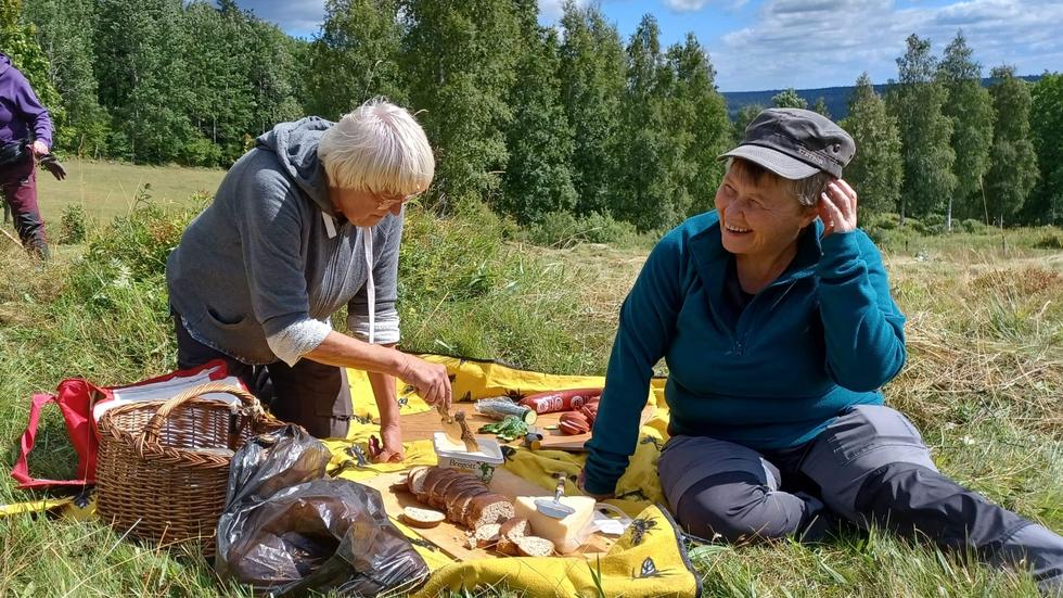 Brita Broberg och Anna Kullenberg dukar upp en välförtjänt fika på den nyslagna ängen i Knaggebo efter lördagens slåtter.