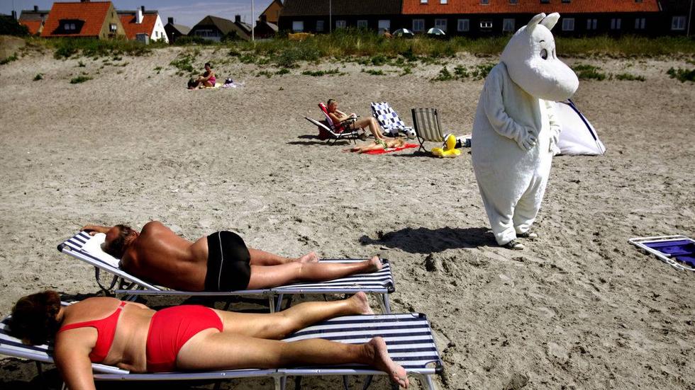 Årets humorbild 2011 är tagen på stranden i Höganäs en het julidag i fjol. Dräkten består av ett stort huvud i plast täckt av ett slags värmande plysch, en jättelik mage i tjock vit filt och ett par tajta, fodrade byxor.