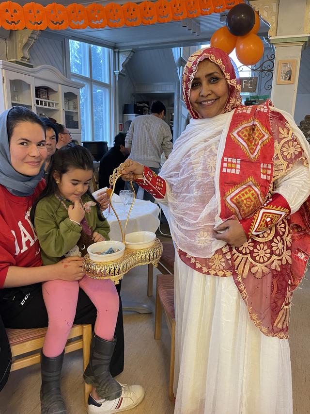 Rahma bjuder kaffegodis till glada och uppskattande gäster.