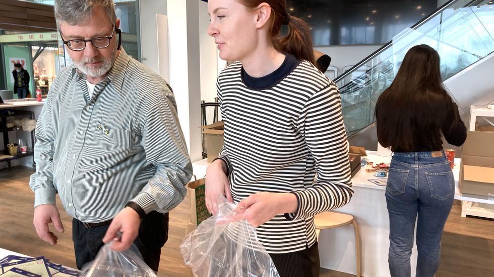 Viktoria Hagstedt, en av volontärerna, hjälper Jörgen Ruther på Sam-Hjälp till rätta vid packbordet för hygienartiklar.