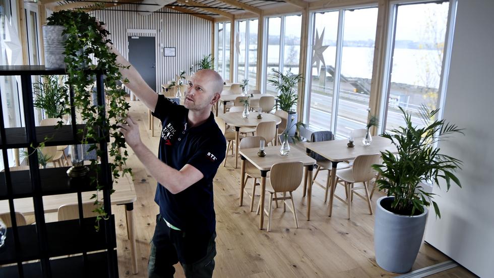 Delägaren Glenn Svärd ställer iordning växter i Kroatorpets nya lokal.
