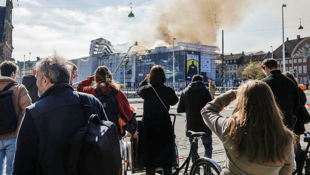 Hundratals köpenhamnare har tagit sig in på cykel och till fots och står flockade bakom polisens avspärrningsband.