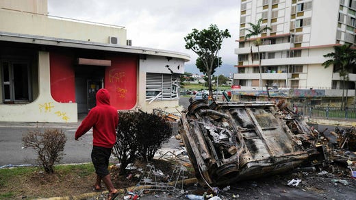 A burning car after riots that took place on Tuesday night in the capital, Noumea.