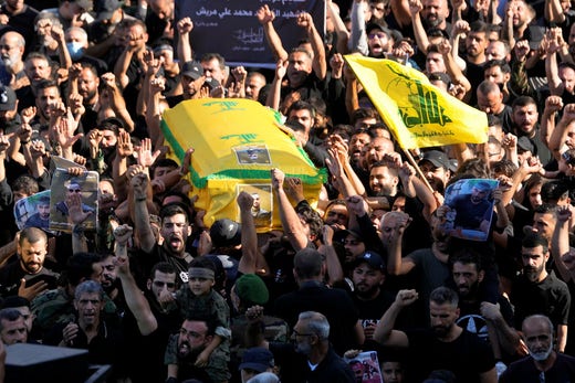 Mourners in southern Beirut chanted slogans as they carried the coffin of one of four Hezbollah members killed in an Israeli air strike on Saturday.