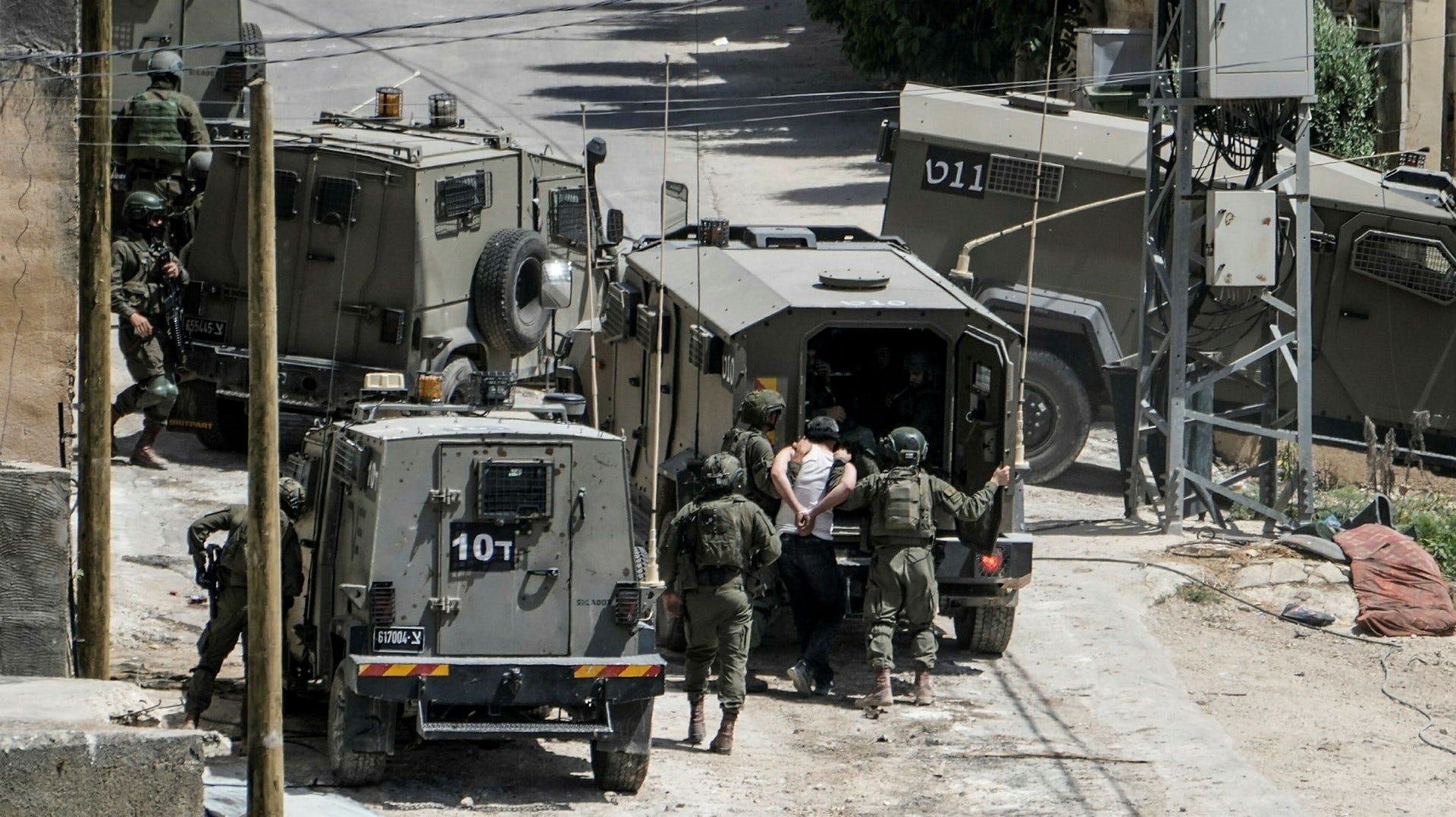 Israeliska soldater frihetsberövar en palestinsk man under en insats på norra Västbanken i början på maj.