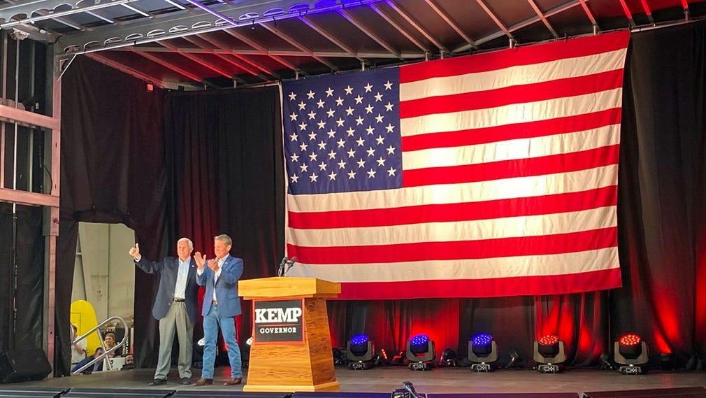 Georgias guvernör Brian Kemp, till höger, tillsammans med den tidigare vicepresidenten Mike Pence på måndagskvällens valmöte på en flygplats utanför Atlanta.