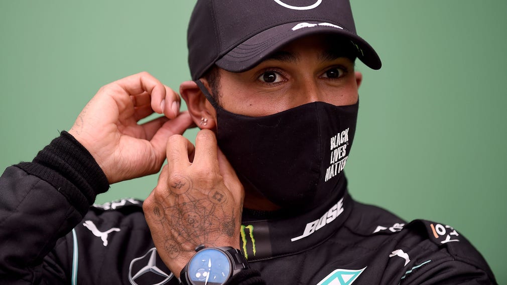Lewis Hamilton rättar till munskyddet.