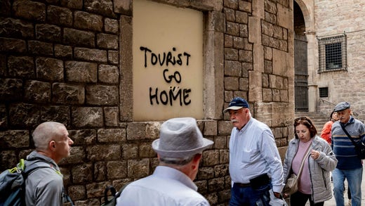Klotter på en fasad i Barcelona uppmanar turister att åka hem.