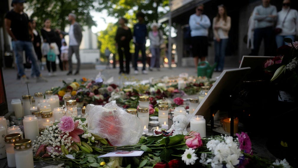 Blommor och ljus på platsen där masskjutningen i Farsta centrum inträffade den 10 juni förra året.