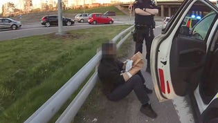 En av de nio män som greps kort efter mordet i Gamlestaden i Göteborg 3 maj i fjol: Här har polisen satt papperspåsar på den gripnes händer för att skydda eventuella spår.